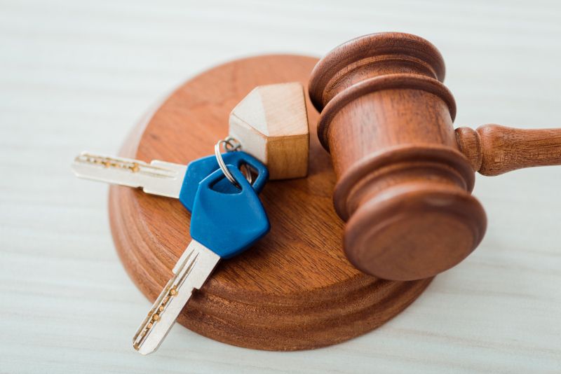 Mazo de un juez con unas llaves de una casa encima. Imagen que representa aperturas tras sentencias judiciales.
